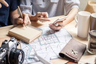 Travelers planning an Orlando vacation with a map, notebook and coffee