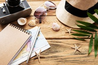 Camera, glasses, maps on the table, vacation planning