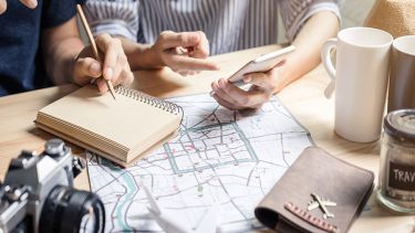 Travelers planning an Orlando vacation with a map, notebook and coffee